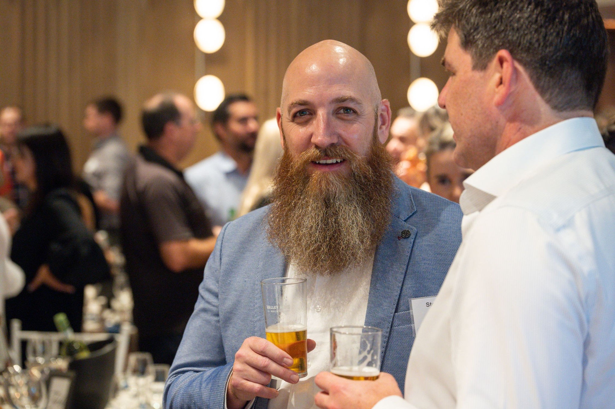 Beard man smiling with a beer in his hand