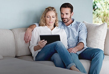 Couple on the couch with their Ipad