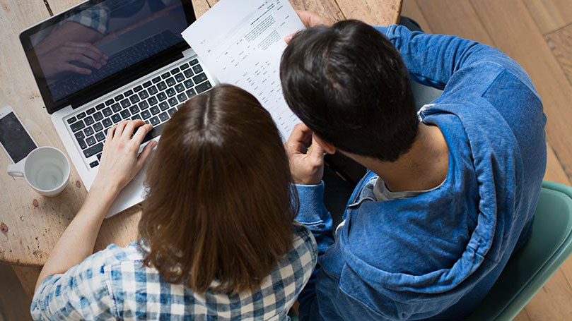 Couple looking at bill invoice while on ipad