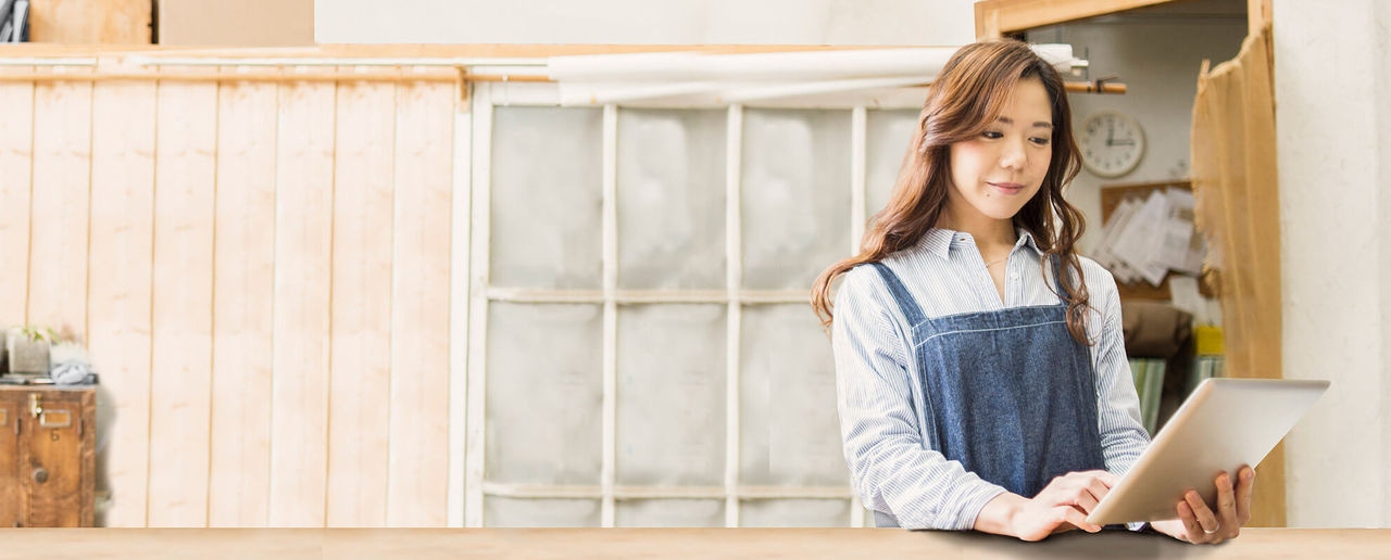 Lady on a laptop with a clock on background