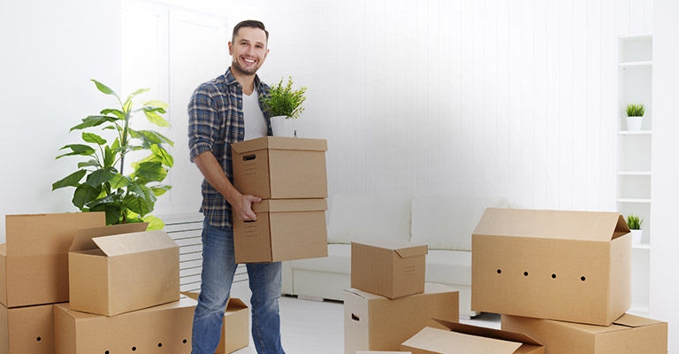 Guy lifting boxes into house