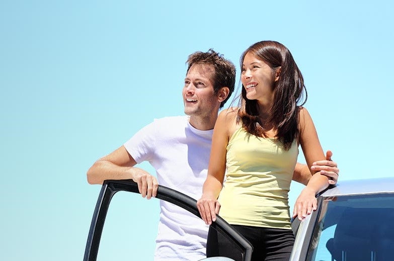 Couple standing with opened drivers side door