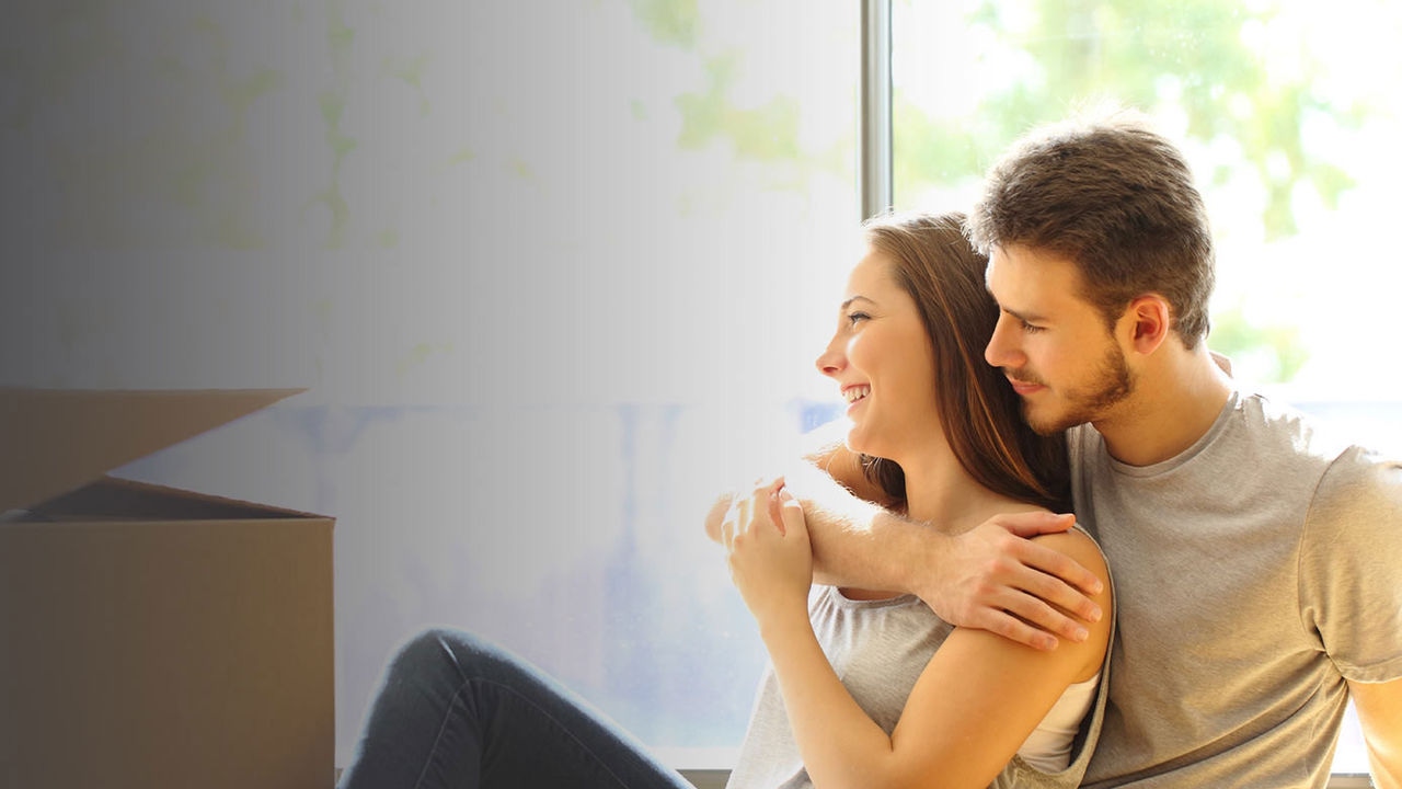 Couple sitting cuddling in front of boxes