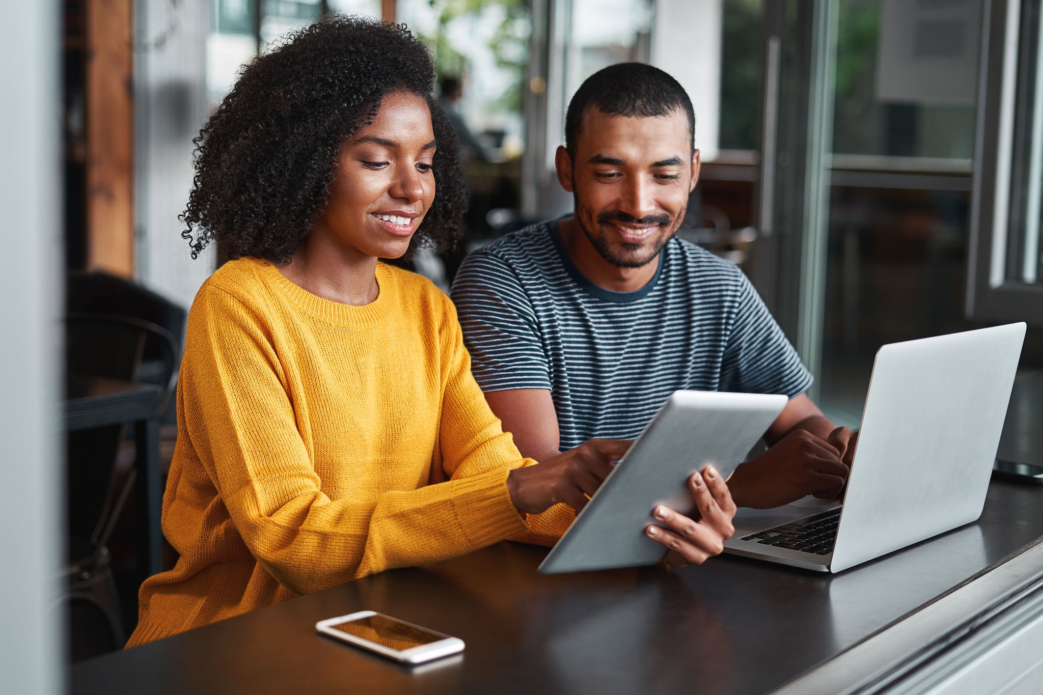 Young couple using digital tablet in cafe