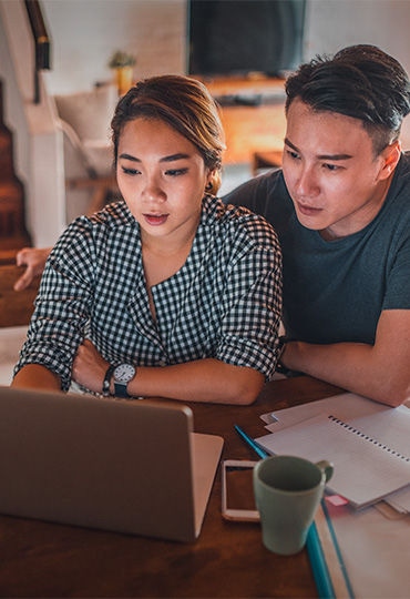 Chinese young couple on laptop in the kitchen