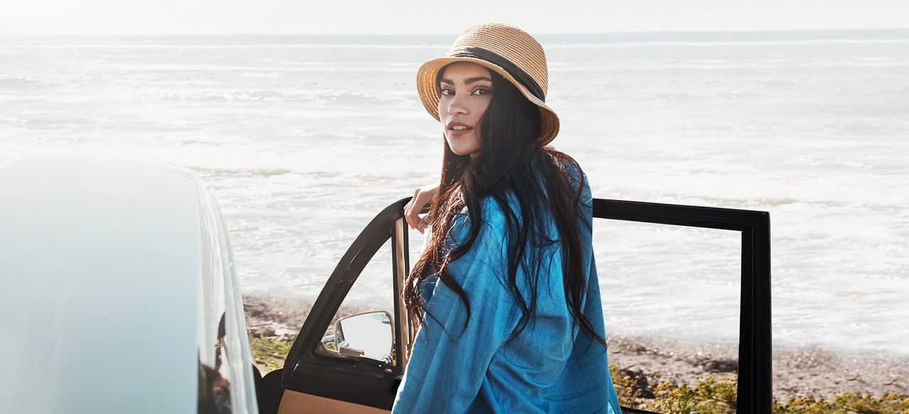 Lady with hat standing by drivers side