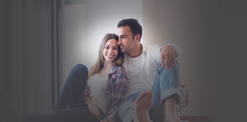 Couple leaning against white wall